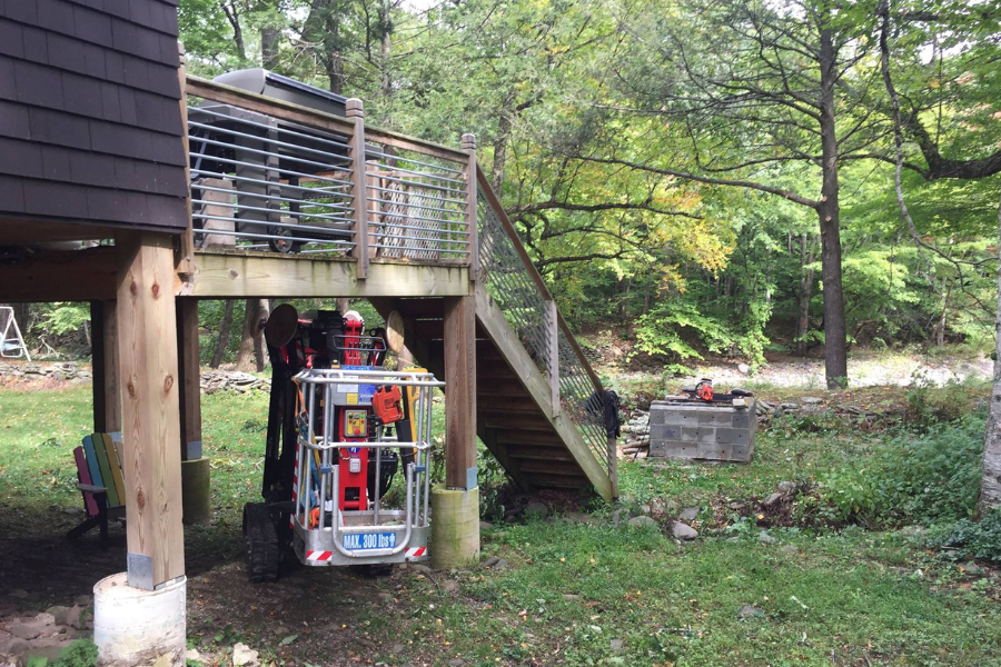 Arborist performing tree removal using bucket truck near home in Catskill NY
